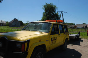 Żółty jeep zaparkowany na polnej drodze w galerii zdjęć.